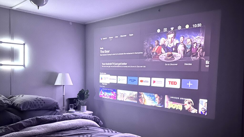 A view of a bedroom with projector screen showing movies