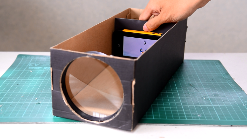 A person making a cardboard projector