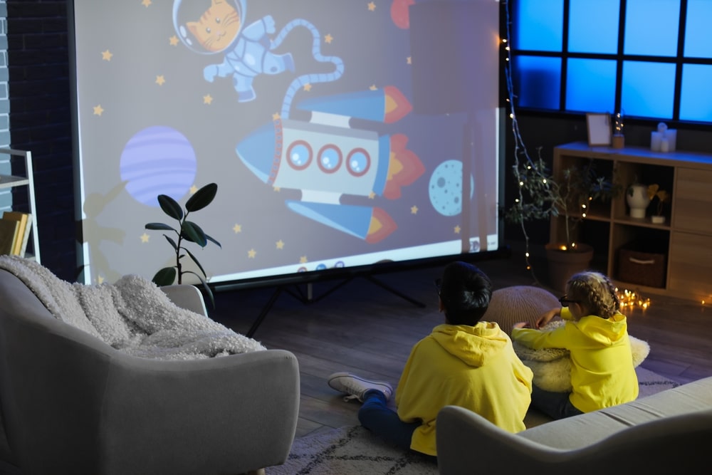 A back view of two boys watching movie on a projector