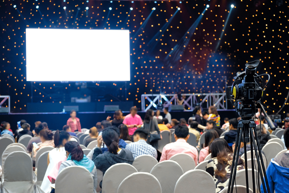 A view of a large crowd of people with movie theatre screen at the front