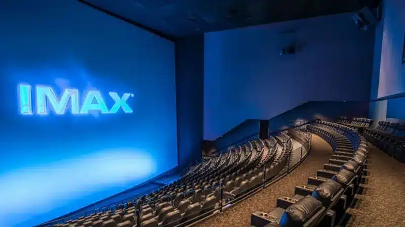 Empty IMAX theater with a large screen displaying the IMAX logo and rows of seats.
