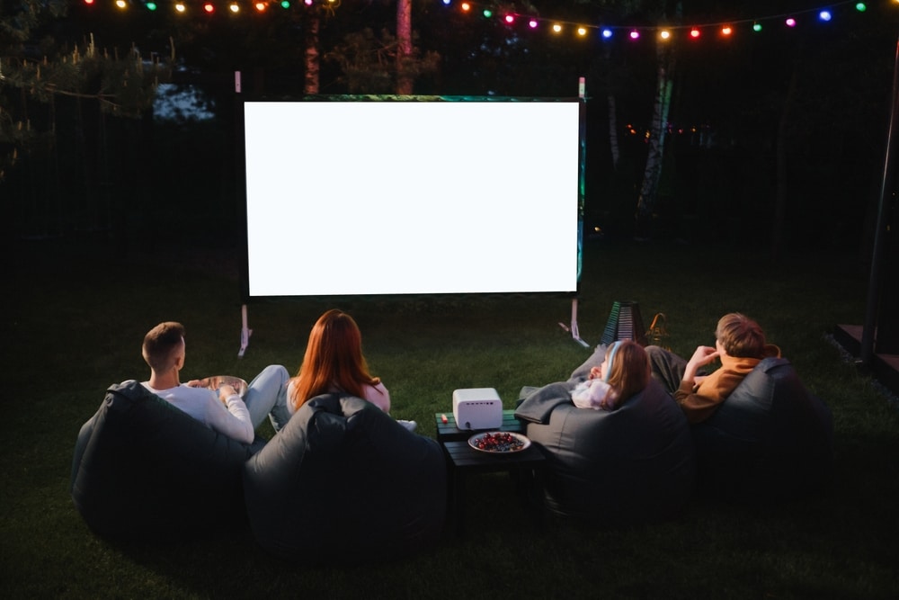 A back view of people staring at a white projector screen