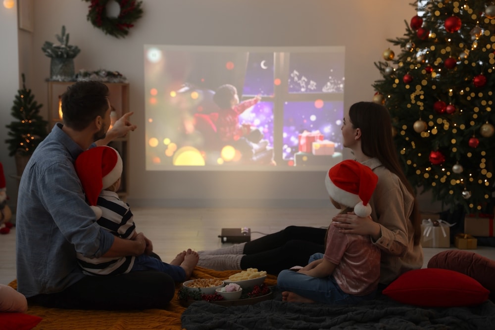 A view of a family watching movie beside a Christmas tree