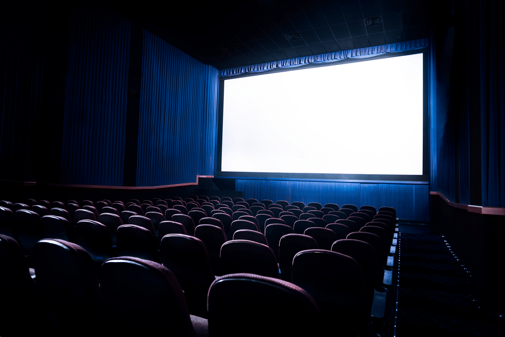 A view of a movie theatre with lit up projector screen