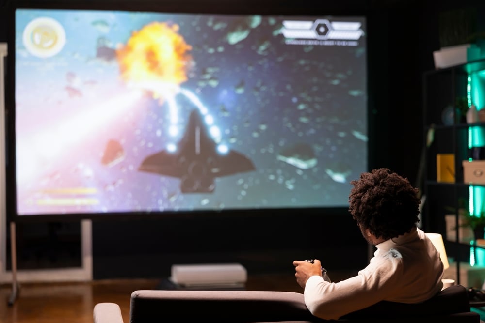 A backview of a person playing game on a projector screen