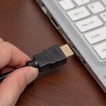 A view of an HMDI cable being inserted a laptop port