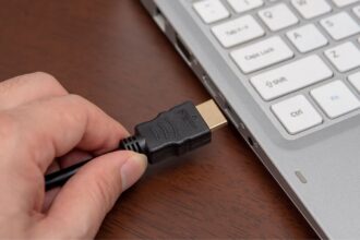 A view of an HMDI cable being inserted a laptop port