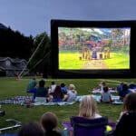 A view of an epic movie projector with people sitting all around