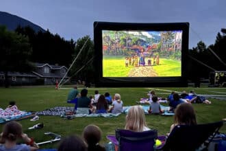 A view of an epic movie projector with people sitting all around