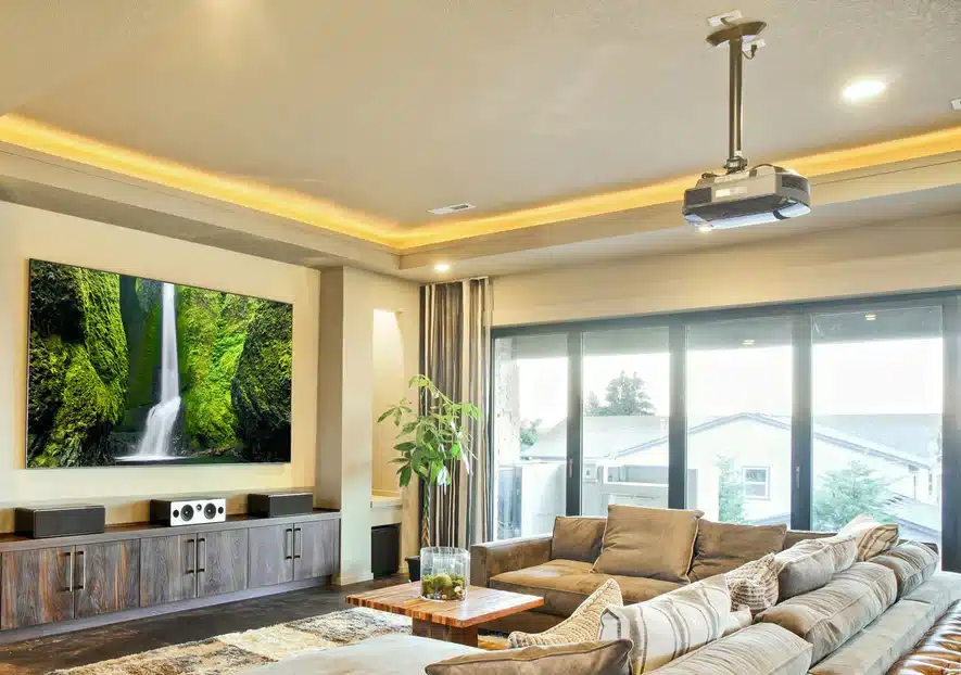 A living room with a ceiling mounted projector and large projected image on the wall