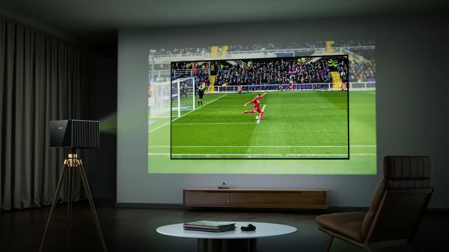 A projector displaying a soccer match on a wall in a living room setting