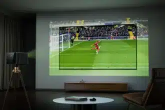 A projector displaying a soccer match on a wall in a living room setting