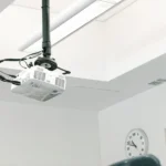 Ceiling mounted projector with cables neatly arranged showcasing a clean and space saving setup